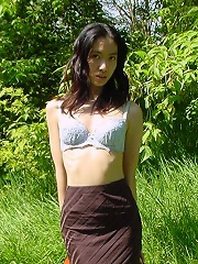 Long haired asian beauty shows her round tits in forest here